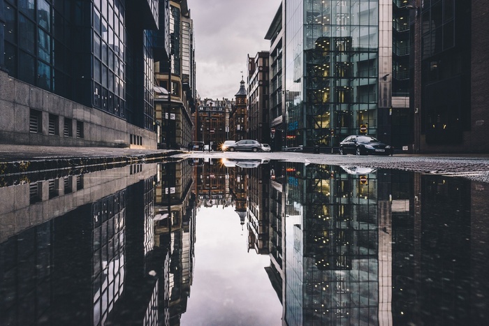 Cars and buildings reflected in a wet city street