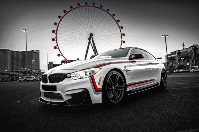 White BMW M4 in front of a Ferris wheel