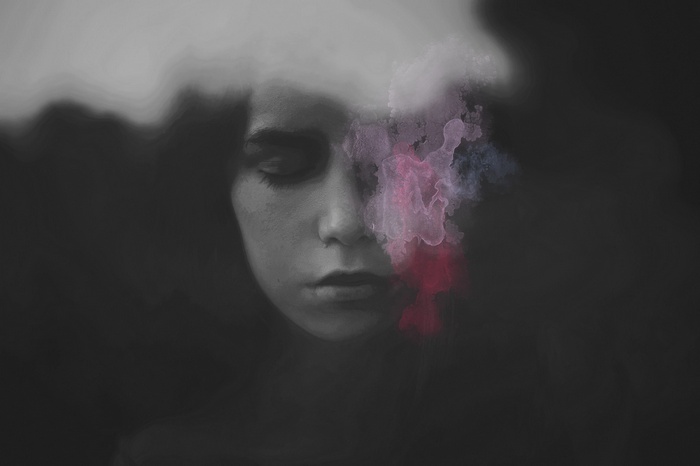 Woman with closed eyes and colorful smoke
