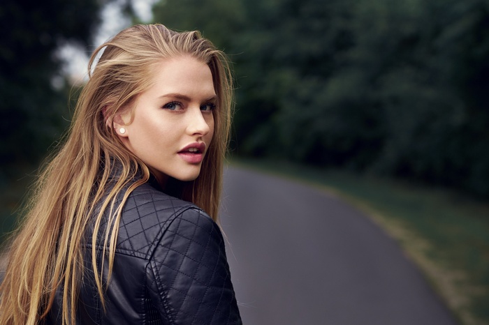 Woman with blonde hair wearing a leather jacket outdoors