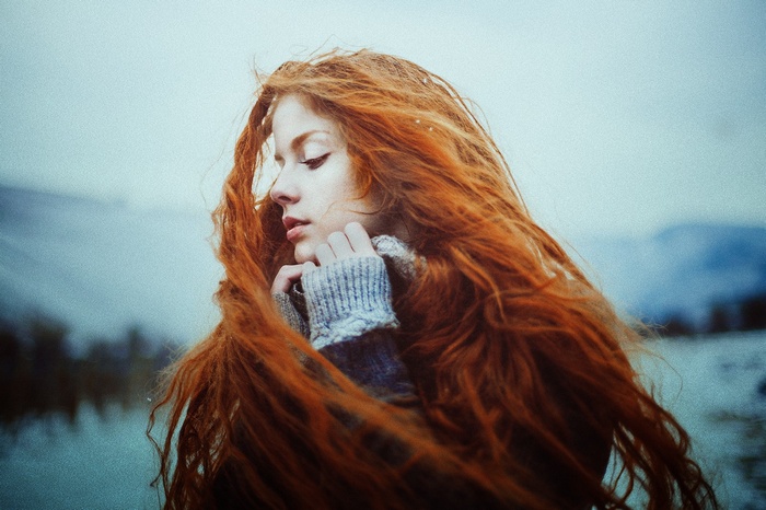Redhead woman with long wavy hair outdoors