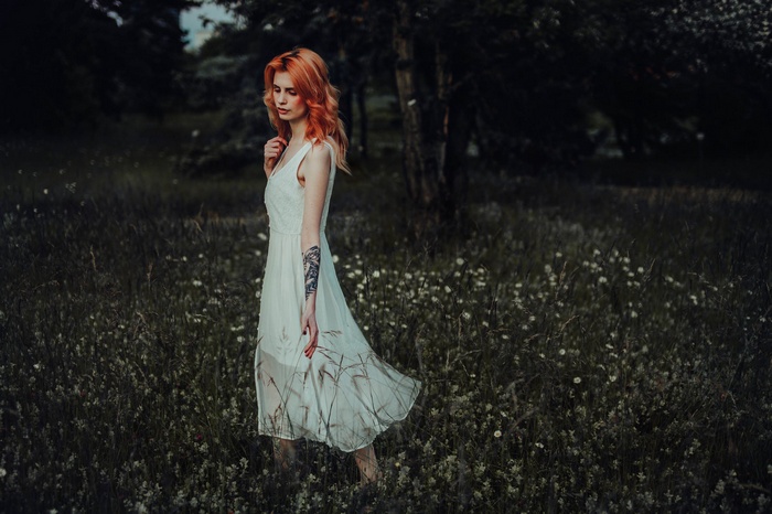 Woman with dyed hair in a white dress in a field