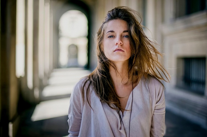 Woman with windblown hair in a colonnade