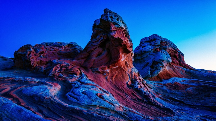 Red and blue sandstone formations under a clear blue sky