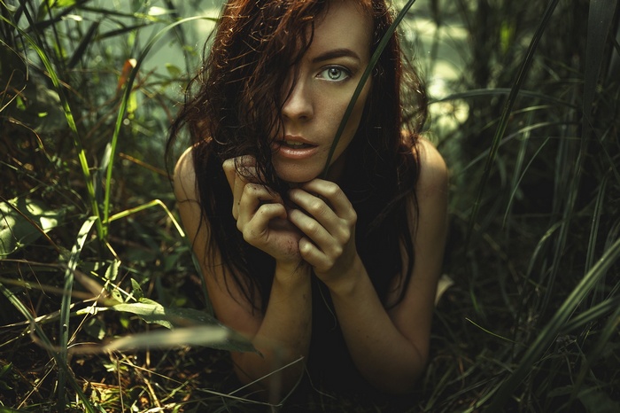 Woman with red hair in tall grass