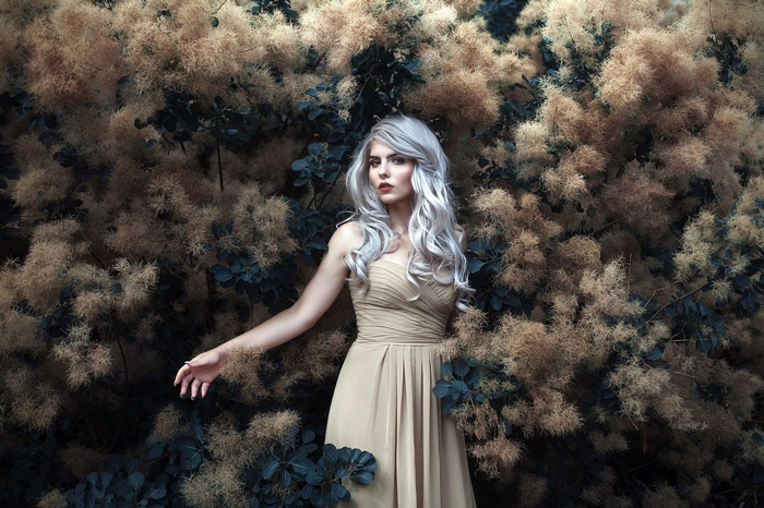 Woman with silver hair in a beige dress
