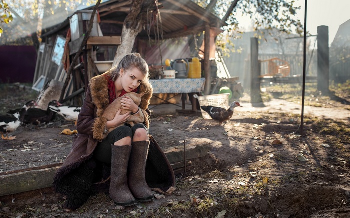 Irina Popova holding a piglet in a farmyard
