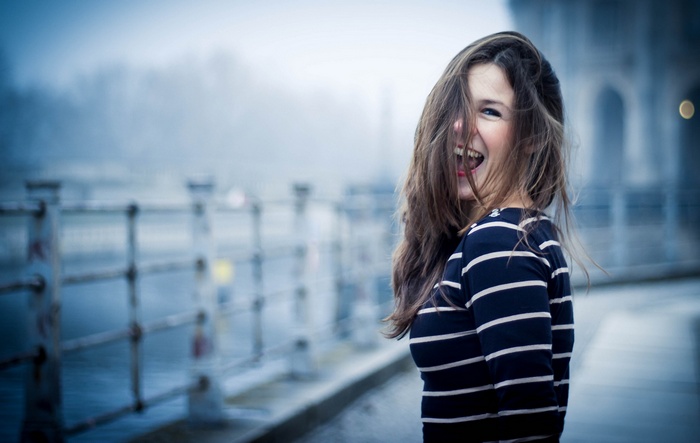 Woman with hair in face wearing striped clothing
