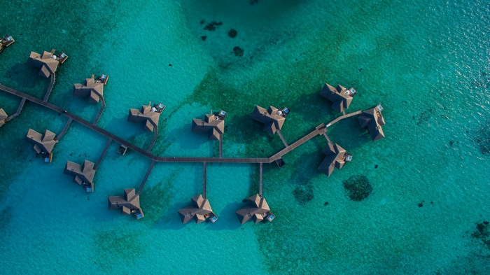 Aerial view of overwater bungalows in turquoise sea