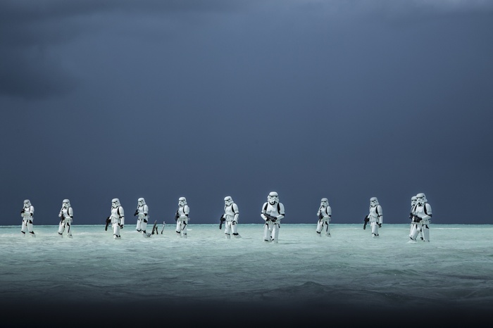 Stormtroopers walking in shallow water under a dark sky