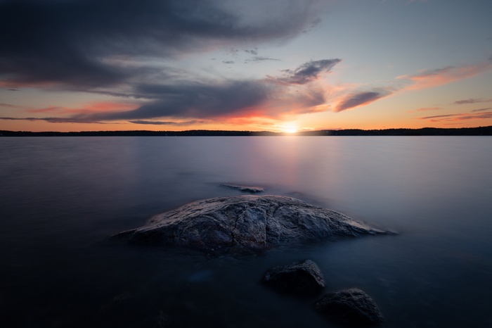Sunset over a calm lake with rocks