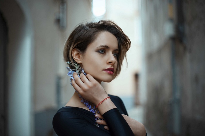 Woman with short hair and flowers in alley