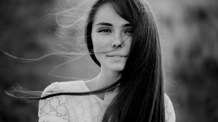 Monochrome portrait of a woman with hair blowing in the wind