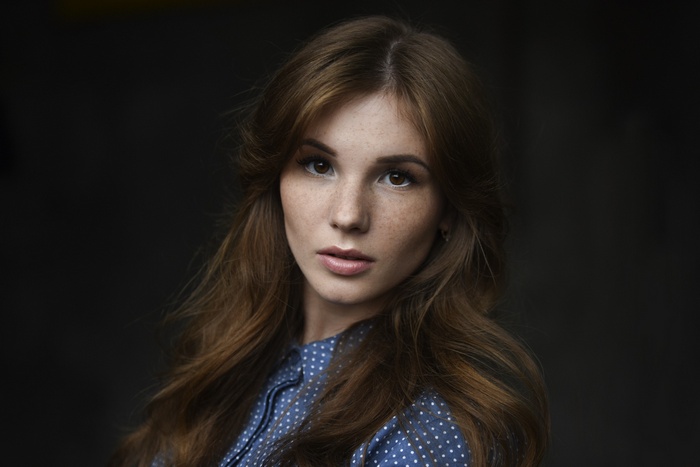 Woman with freckles wearing a blue polka dot shirt
