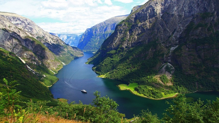 Boat on a fjord surrounded by mountains in Norway