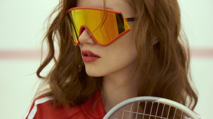 Woman with Oakley sunglasses and tennis racket