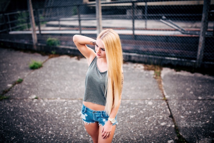 Blonde woman with tattoos wearing jean shorts