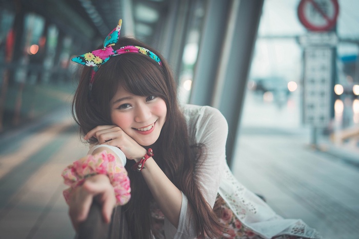 Asian woman with floral headband smiling
