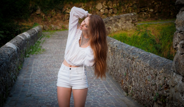 Woman in white outfit on a stone bridge