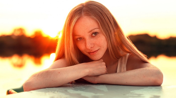 Young woman with freckles at sunset