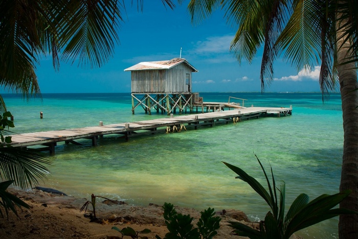 Wooden dock leading to a stilted hut in the Caribbean Sea