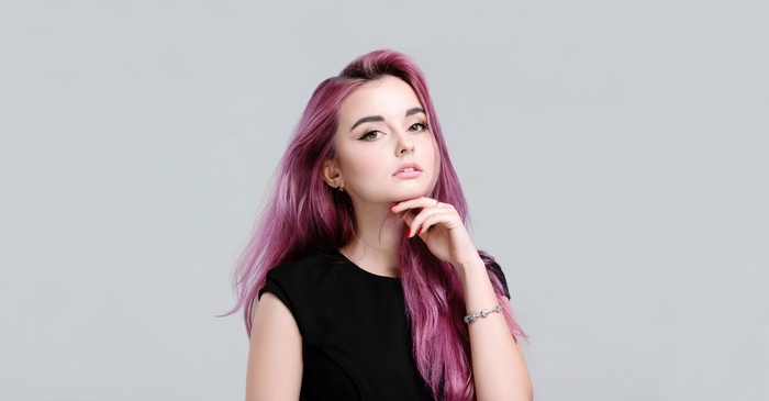 Woman with pink dyed hair in a black dress