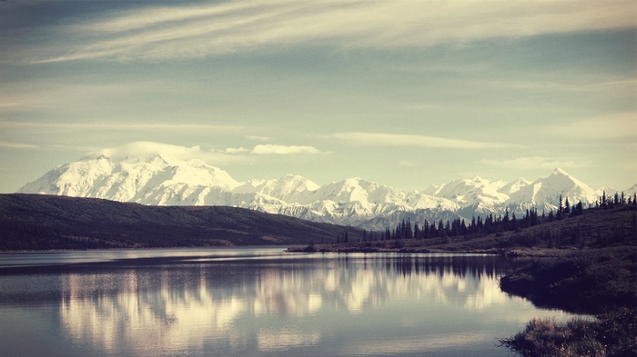 Snow-capped mountains reflected in a calm lake