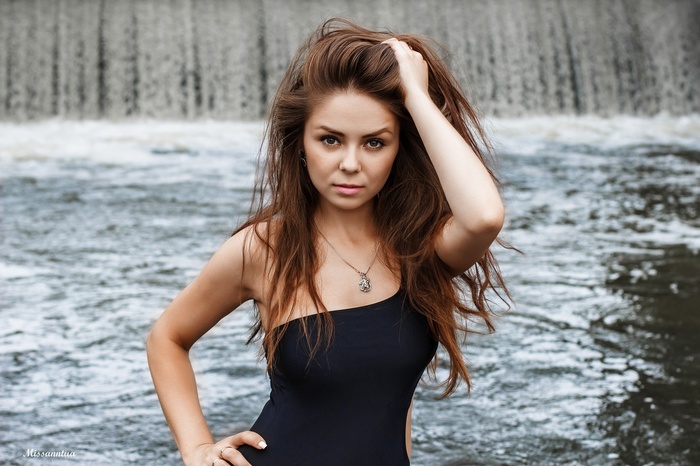 Woman with long brown hair at a waterfall