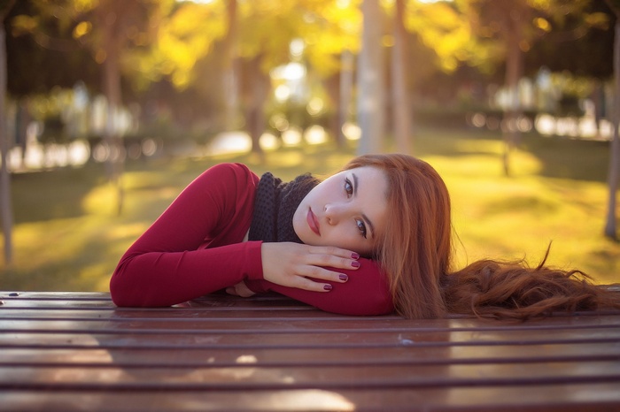Woman with red hair lying on a table outdoors