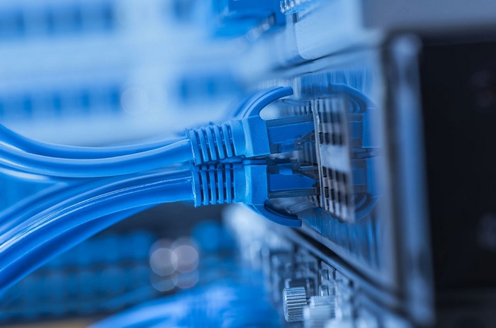 Blue network cables plugged into a server rack