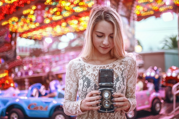 Woman holding a vintage camera at a carnival