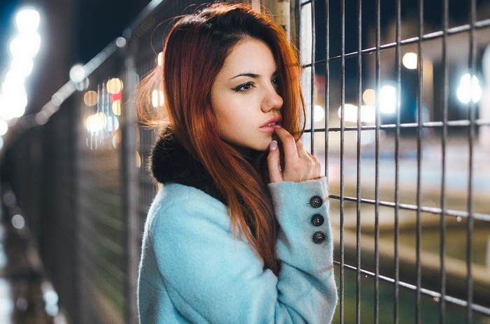 Delaia Gonzalez with finger on lips in a light blue coat