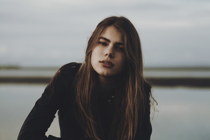 Woman with long brown hair looking at viewer