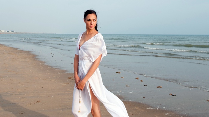 Gal Gadot in a white dress on a beach
