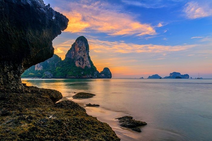 Thailand island beach with limestone karsts at sunset