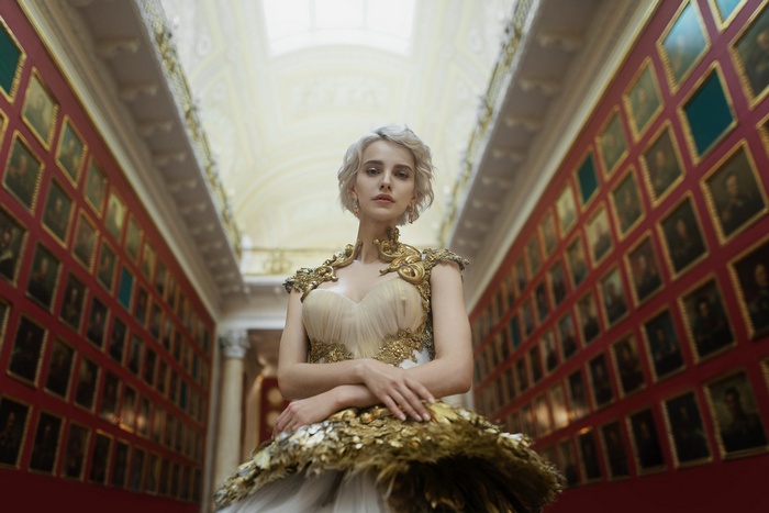 Woman in a golden dress in a museum