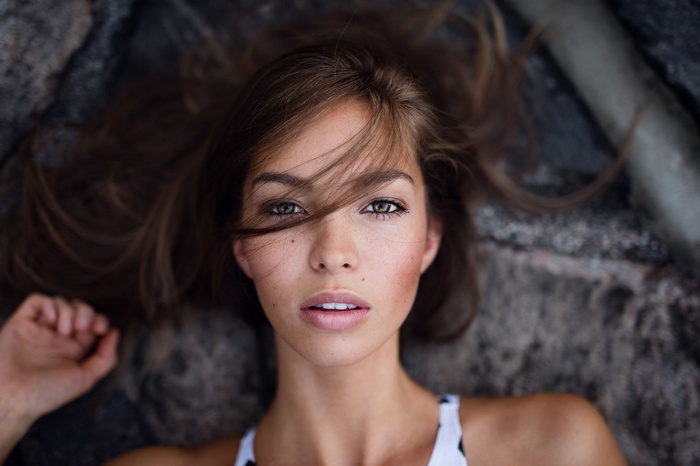 Woman with hair in face lying on rocks