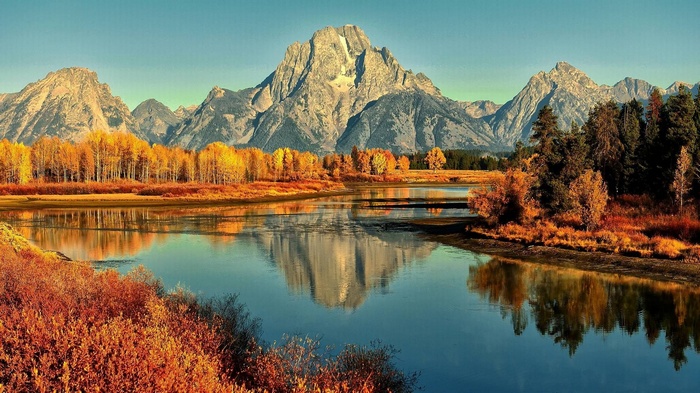 Mountains reflected in a river during autumn