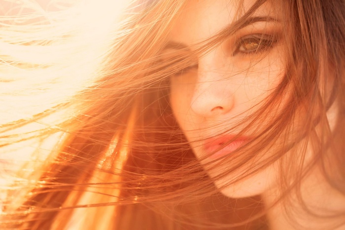 Close-up of a woman's face with hair blowing