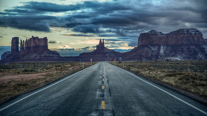 Road leading to Monument Valley under cloudy sky