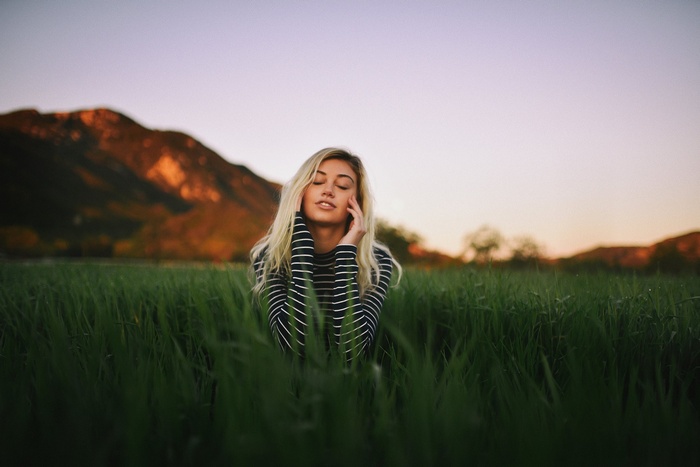 Woman with blonde hair sitting in a field
