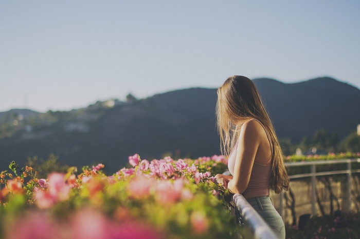 Woman with long brown hair looking at flowers