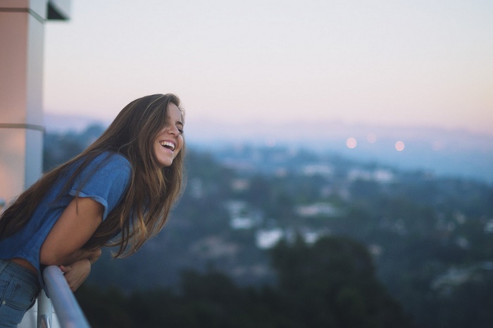 Tia Liu laughing on a balcony at sunset