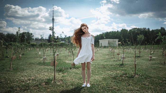 Redhead woman in white dress in a field