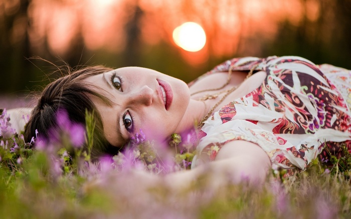 Woman lying in flowers looking at viewer