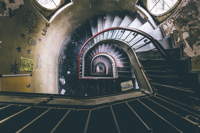 Abandoned spiral staircase with graffiti