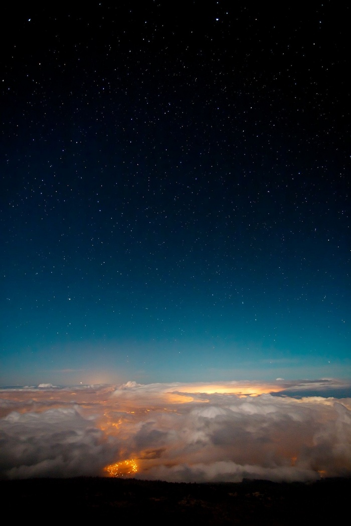 Night sky over clouds and city lights
