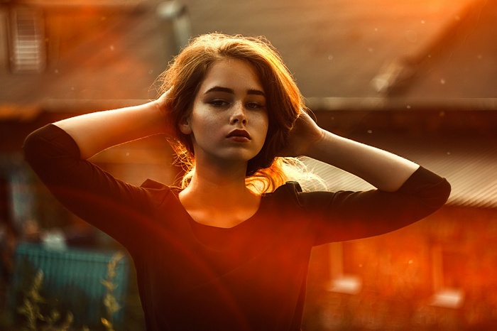Portrait of a young woman with hands on her head