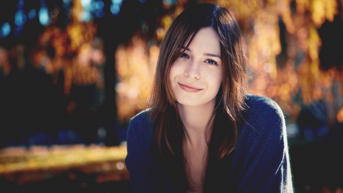 Woman smiling in a park during fall