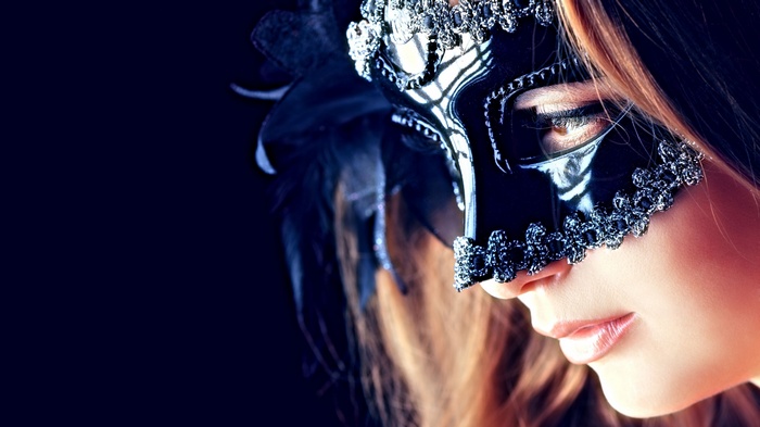 Woman wearing a black ornate masquerade mask